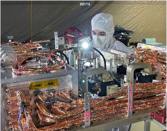 An engineer inspects the radio frequency (RF) panel of NASA's Europa Clipper in a cleanroom at the Johns Hopkins Applied Physics Laboratory in Laurel, Maryland.