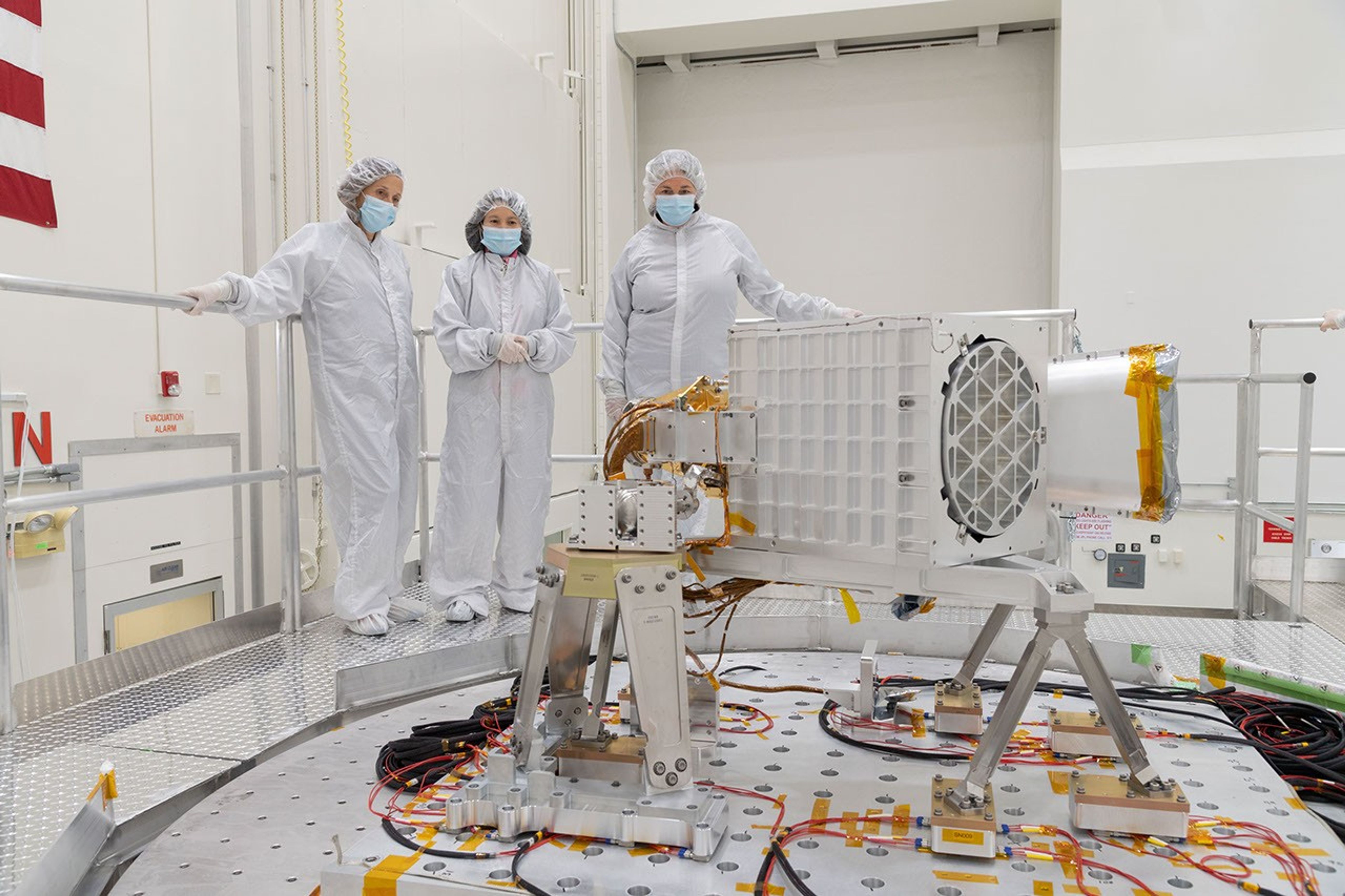 Officials from NASA and JPL oversee vibration testing of the EMIT science instrument, including its telescope and imaging spectrometer.