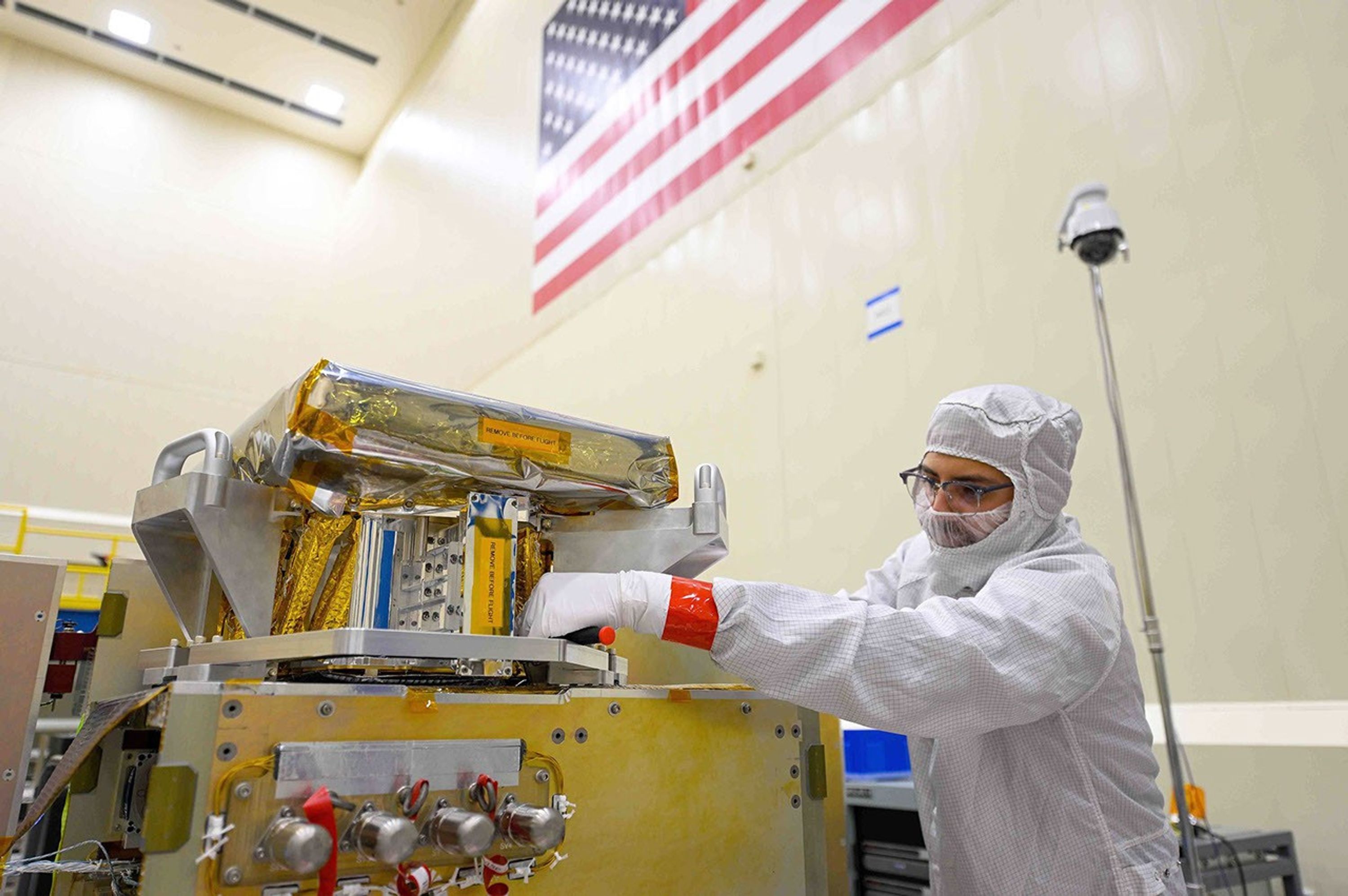 The side of the High-resolution Volatiles and Minerals Moon Mapper (HVM³) is seen as the instrument gets unwrapped in a clean room. The JPL-developed imaging spectrometer was later integrated with NASA's Lunar Trailblazer spacecraft.