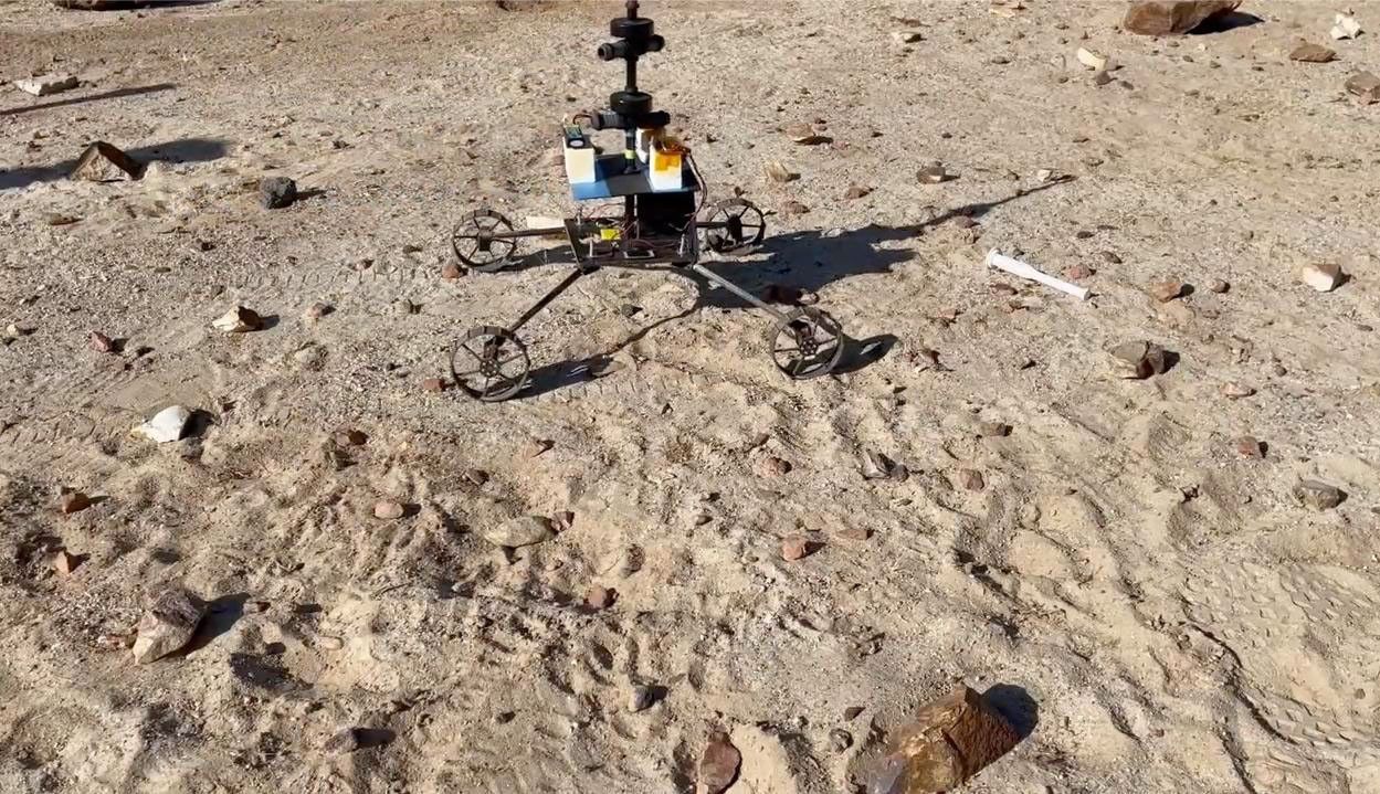 A model Sample Recovery Helicopter drives and positions itself over a sample tube during a test in the Mars Yard at NASA's Jet Propulsion Laboratory in Southern California.