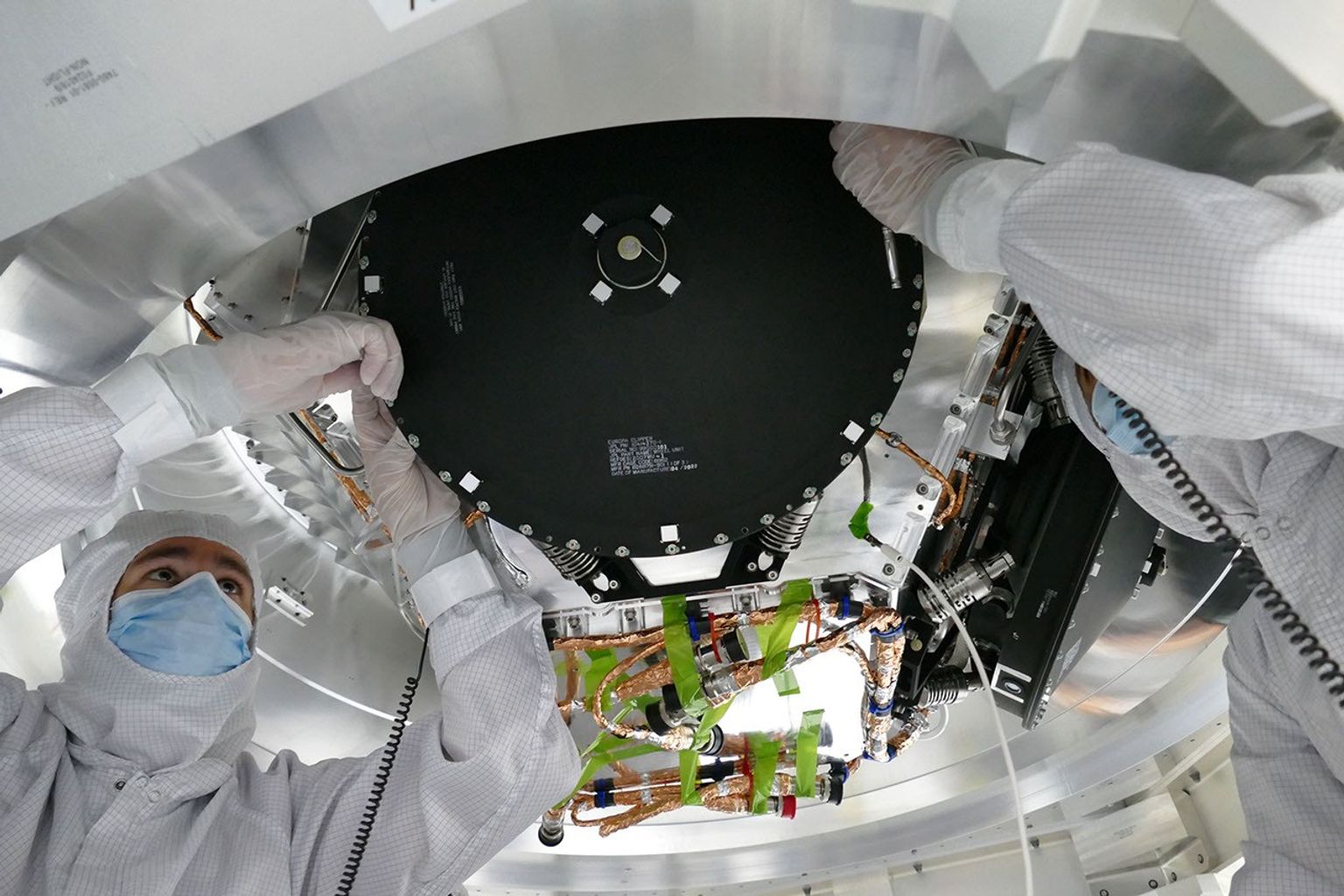 Engineers install 2-foot-wide reaction wheels onto the main body of NASA's Europa Clipper spacecraft. The orbiter is in its assembly, test, and launch operations phase in preparation for a 2024 launch.