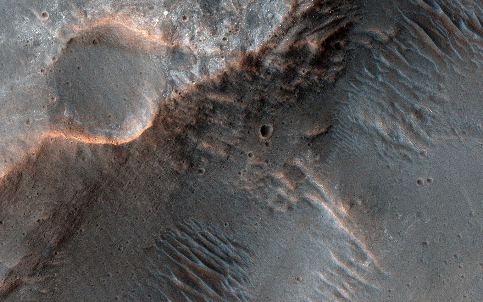 This image acquired on June 8, 2022 by NASA's Mars Reconnaissance Orbiter shows channels cutting through the ancient rim of Savich Crater.