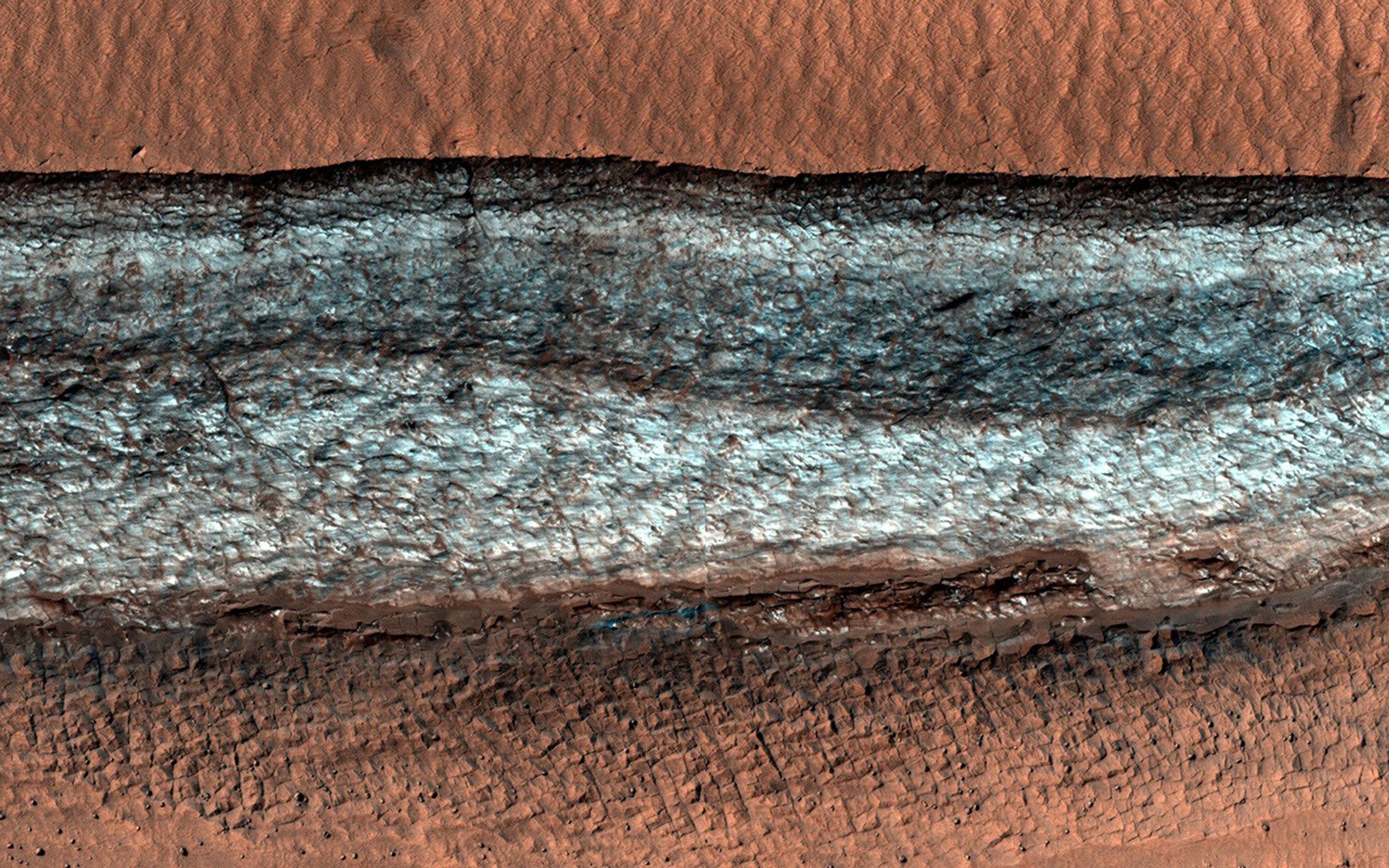 This image acquired on July 20, 2022 by NASA's Mars Reconnaissance Orbiter shows a cliff that cuts through the terrain and gives us a glimpse of the buried icy material.