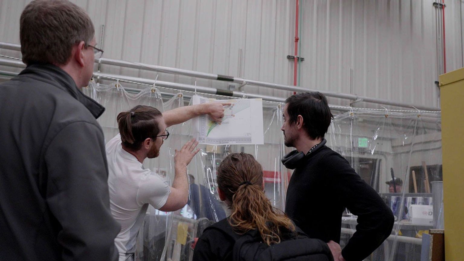 JPL engineer Patrick DeGrosse reviews data from a drop test of a full-size lander footpad with a group of fellow engineers.