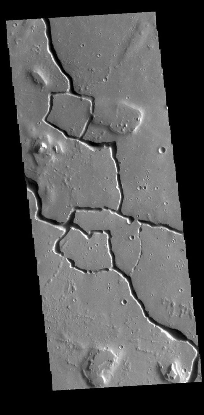 This image from NASA's Mars Odyssey shows part of Hephaestus Fossae. Hephaestus Fossae is a complex channel system in Utopia Planitia near Elysium Mons.
