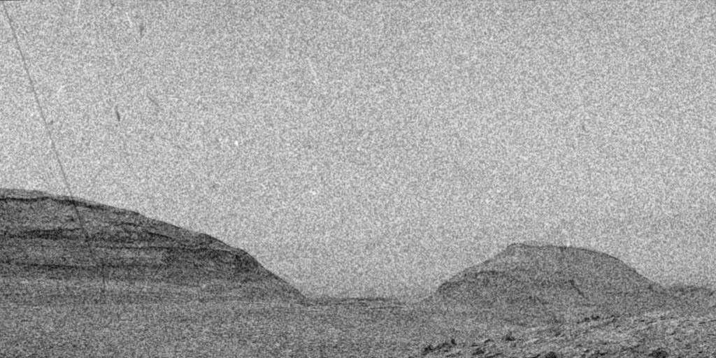 NASA's Curiosity Mars rover captured streaks and specks using one of its navigation cameras just as particles from a solar storm arrived on the Martian surface. These artifacts are caused by energetic particles hitting the camera's image detector.