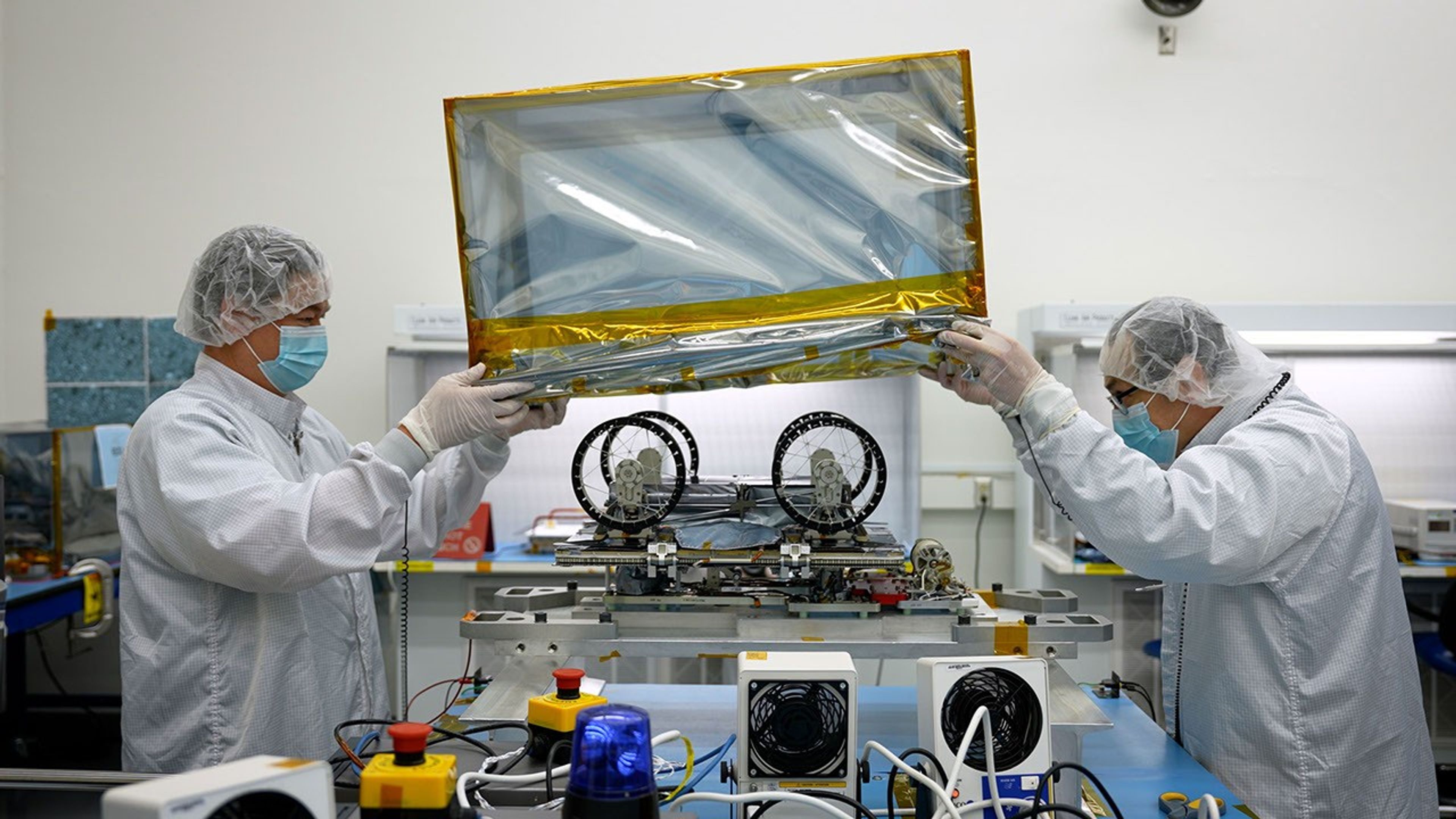 Engineers and technicians prepare one of three small lunar rovers that are part of a NASA technology demonstration called CADRE, in a clean room at the agency's Jet Propulsion Laboratory on Jan. 29, 2025.