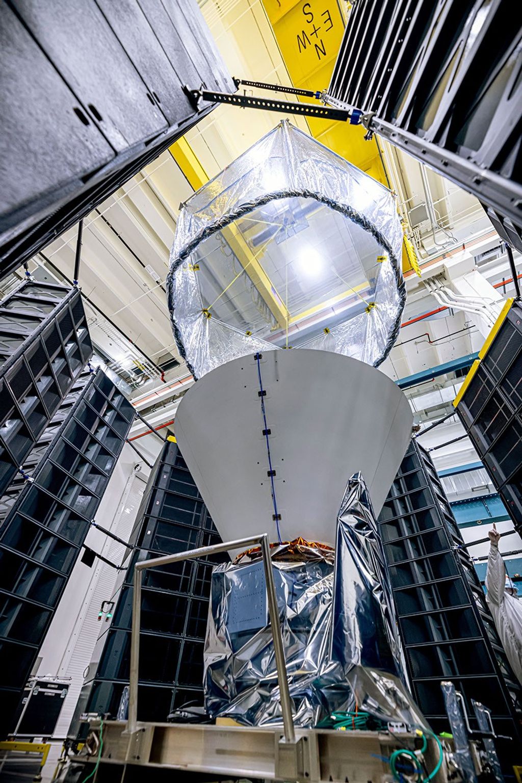 NASA's SPHEREx observatory is surrounded by speaker stacks used to perform acoustics testing, which subjects the spacecraft to the acoustics loads that it will experience during launch.