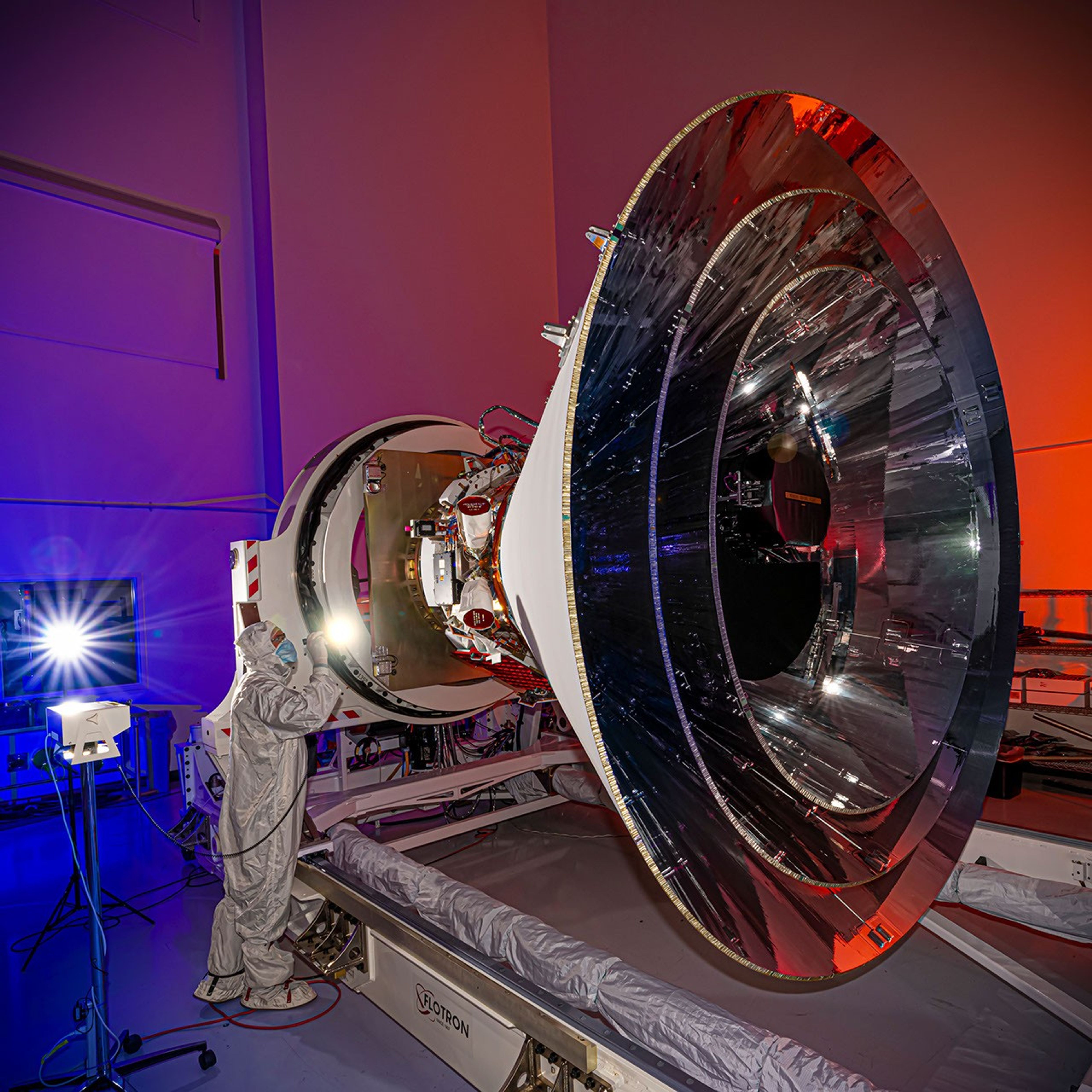 NASA's SPHEREx observatory is oriented in a horizontal position, revealing all three layers of photon shields as well as the telescope.