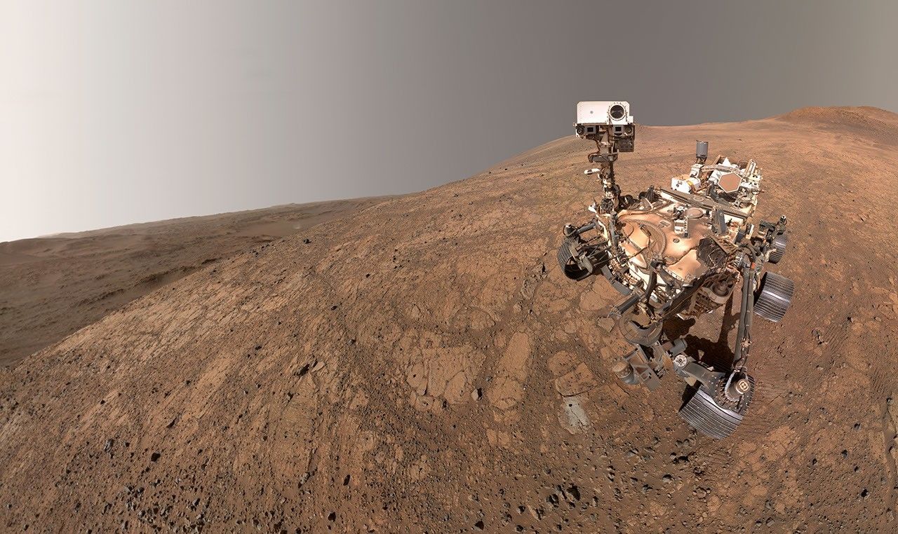 NASA's Perseverance took this selfie on May 10, 2025. The small puff of dust left of center and below the horizon line is a dust devil.