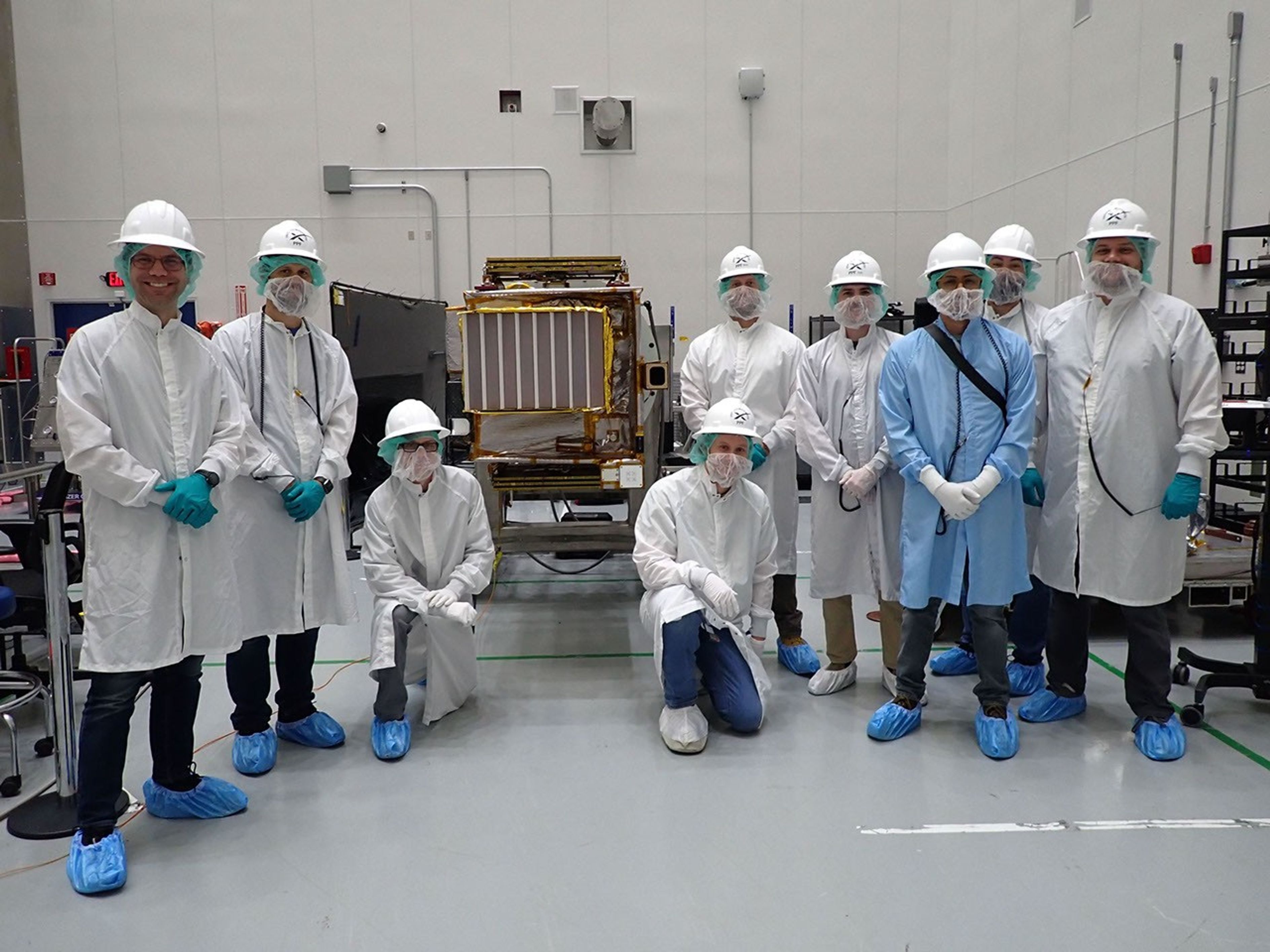 Members of NASA's Lunar Trailblazer team pose with the spacecraft at SpaceX's Payload Processing Facility at NASA's Kennedy Space Center in Florida in early February 2025.