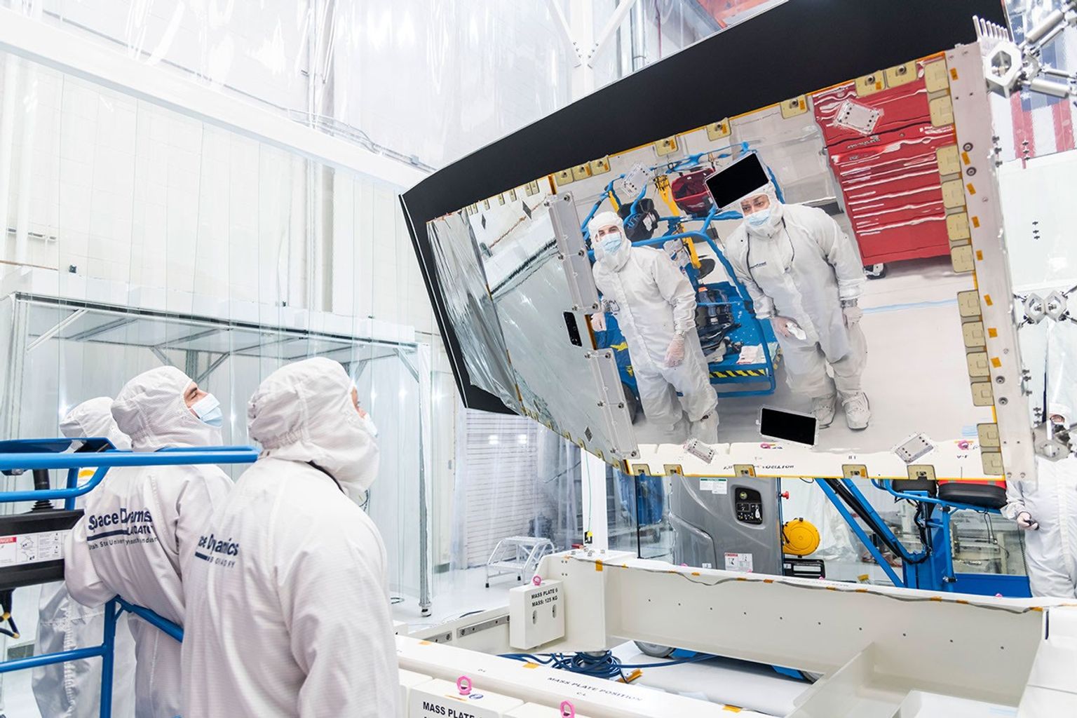Technicians and engineers inspect NASA's NEO Surveyor's instrument enclosure at the Space Dynamics Laboratory (SDL) in Logan, Utah, after it arrived from the agency's Jet Propulsion Laboratory in May 2025.
