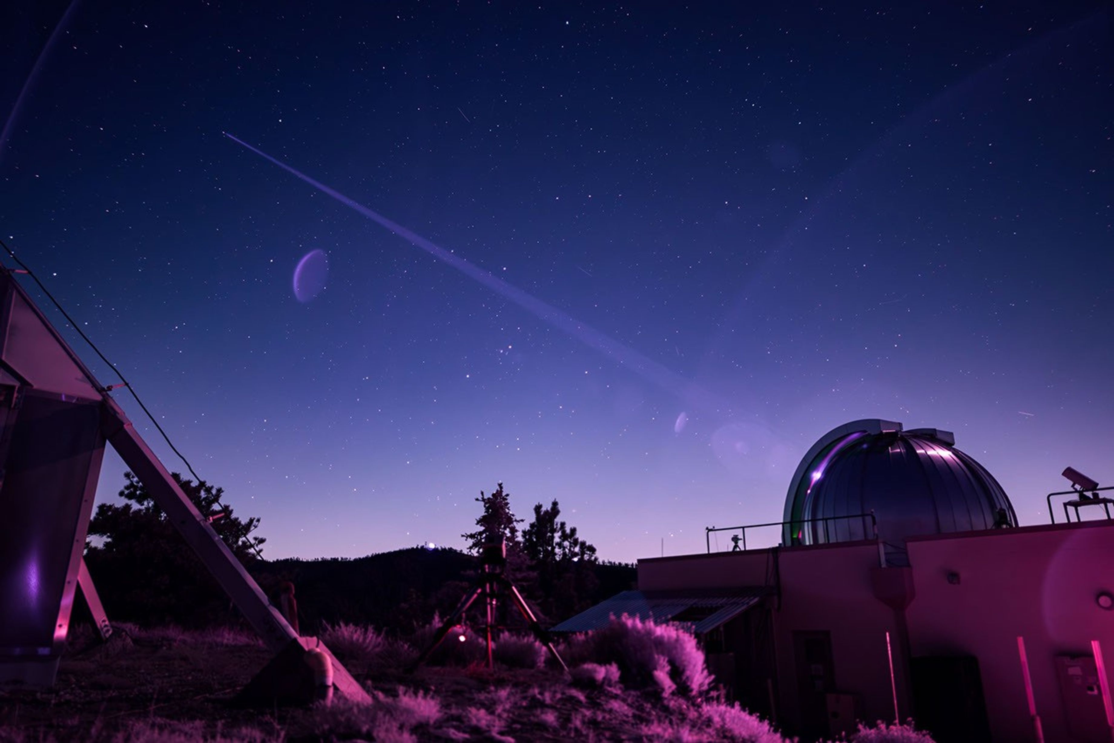In this infrared photograph, the Optical Communications Telescope Laboratory at NASA JPL's Table Mountain Facility, beams its laser beacon to the DSOC flight laser transceiver aboard NASA's Psyche spacecraft.