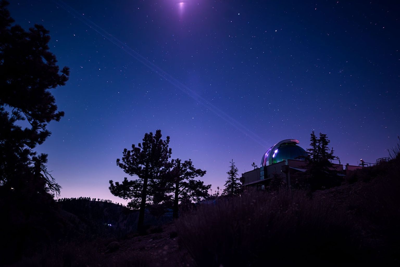In this infrared photograph, the Optical Communications Telescope Laboratory at JPL's Table Mountain Facility beams its laser beacon to the DSOC flight laser transceiver aboard NASA's Psyche spacecraft.