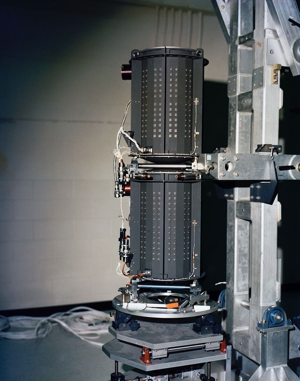 Two black cylinders with fins are stacked on top of each other on a rolling platform.