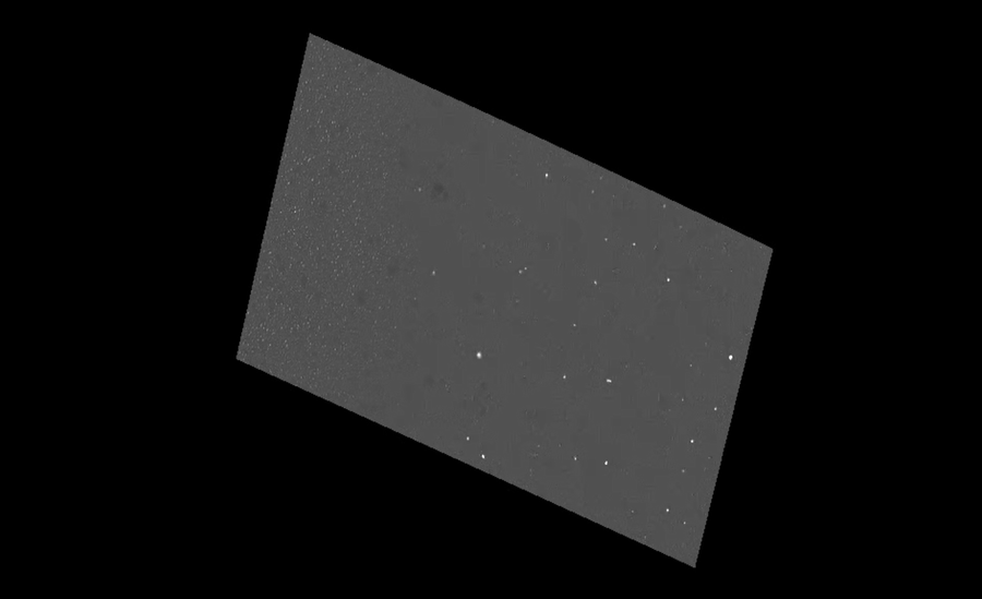 Comet 3I/ATLAS appears as a small point of light near the center of the frame against a processed background of stars