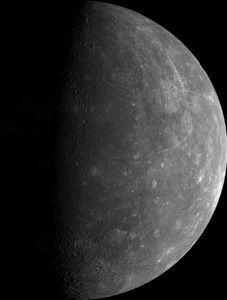 Gray planet Mercury against the darkness of space. White rays from craters can be seen.