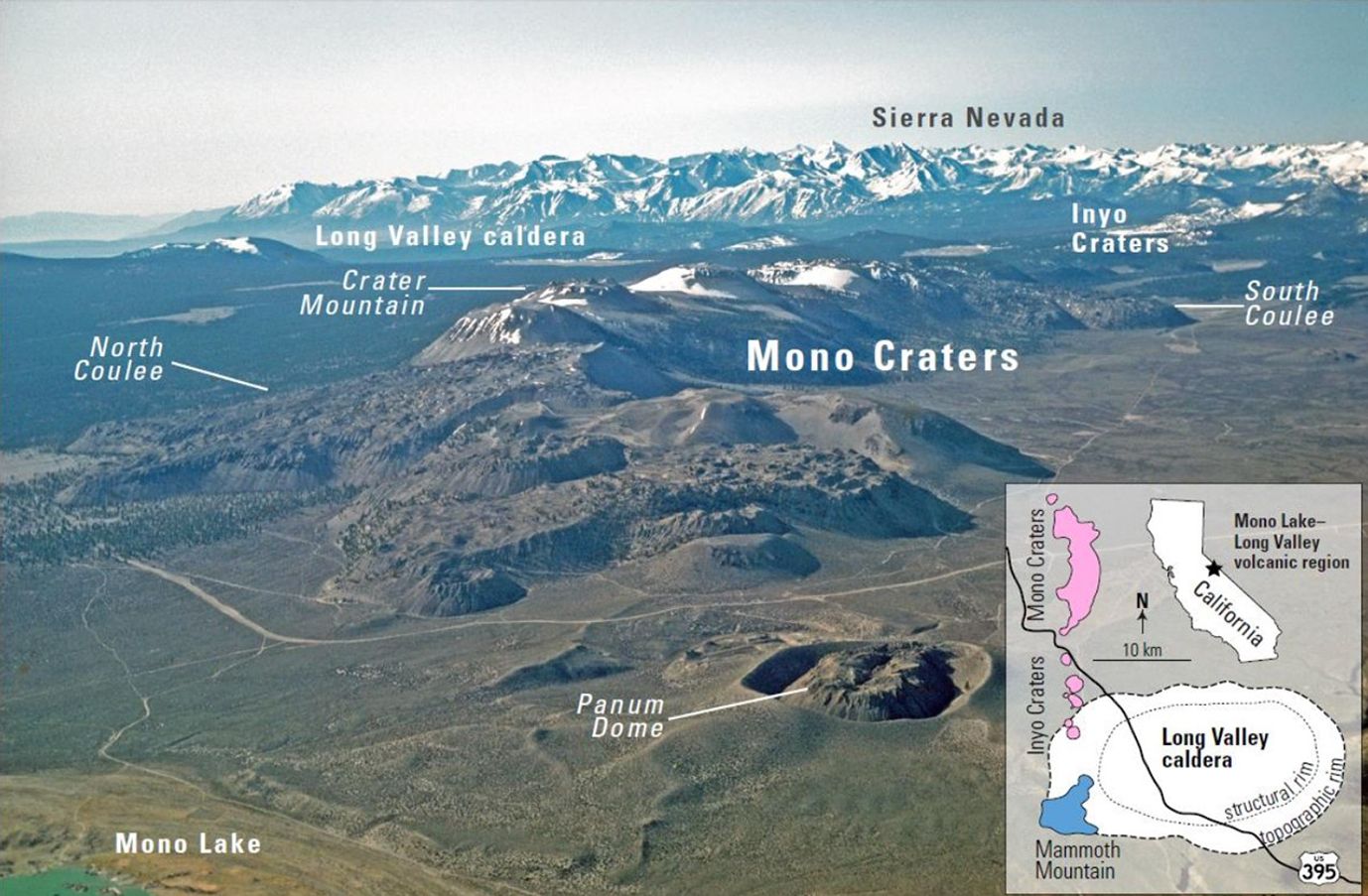 Oblique aerial view looking towards the Sierra Nevada mountains on the horizon. At the foot of the mountains is (left) a flat area labeled “Long Valley Caldera” and (right) a region labeled “Inyo Craters”. Next closest to the camera is a smaller mountain range with three areas labeled: North Coulee, Crater Mountain, and South Coulee. Tucked at the foot of these mountains is a flatter zone labeled “Mono Craters”. Around the mountains, a road winds through flat land. In the foreground is a crater containing a lump labeled “Panum Dome” (right), and a small segment of waterline labeled “Mono Lake” (bottom left corner). An inset map indicates the pictured region’s location within the state of California: about halfway up, near the Eastern border.