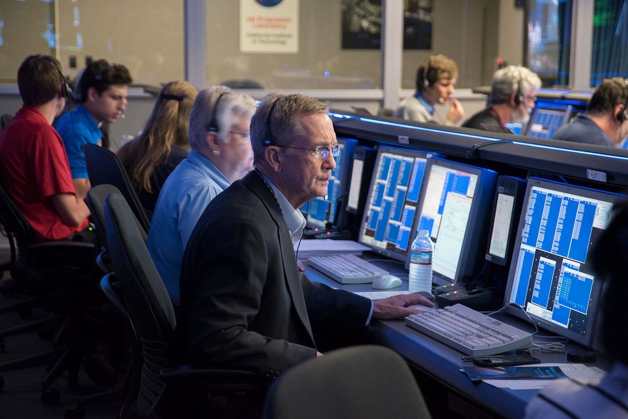 People sitting in rows in front of computer monitors