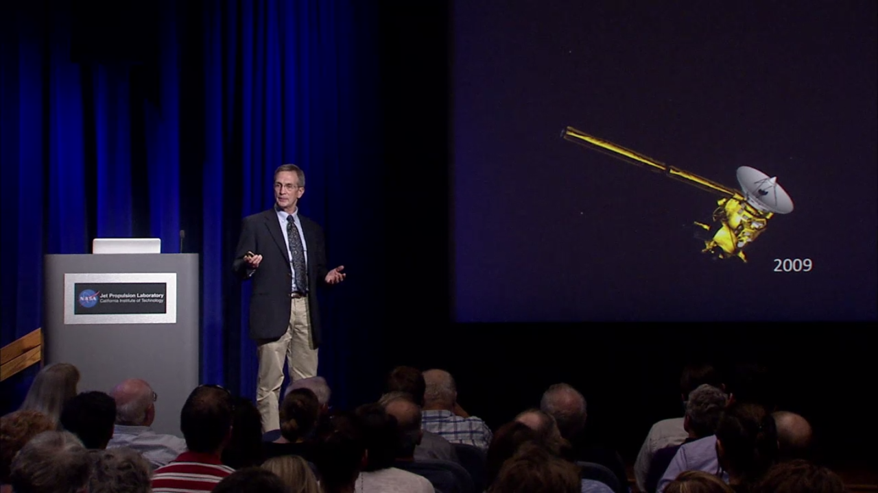 Color image of man speaking to a crowd.