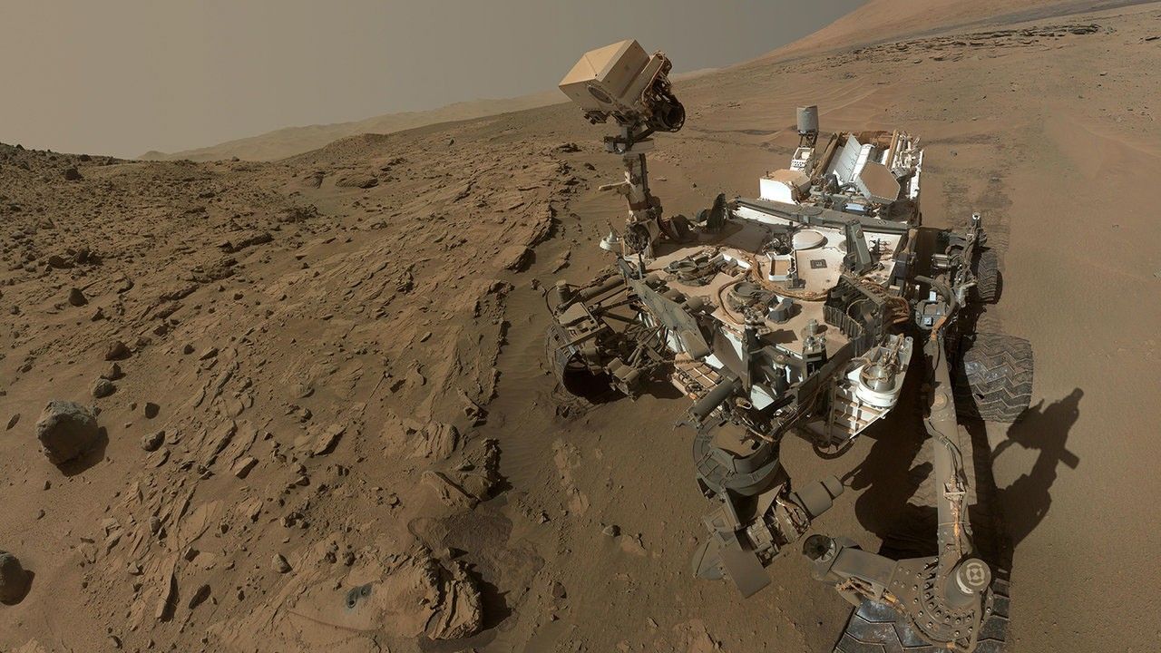 Rover sitting on Mars covered in dust.