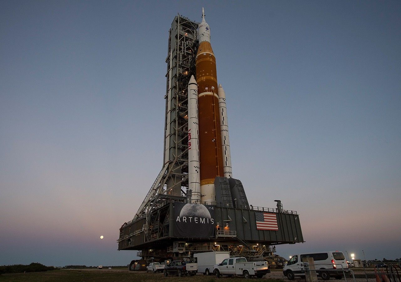 Moon rising behind a huge NASA rocket