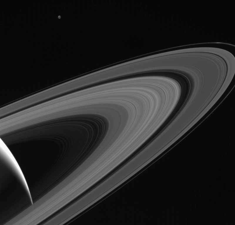 Cassini gazes across the icy rings of Saturn toward the icy moon Tethys, whose night side is illuminated by Saturnshine, or sunlight reflected by the planet. › Full image and caption
