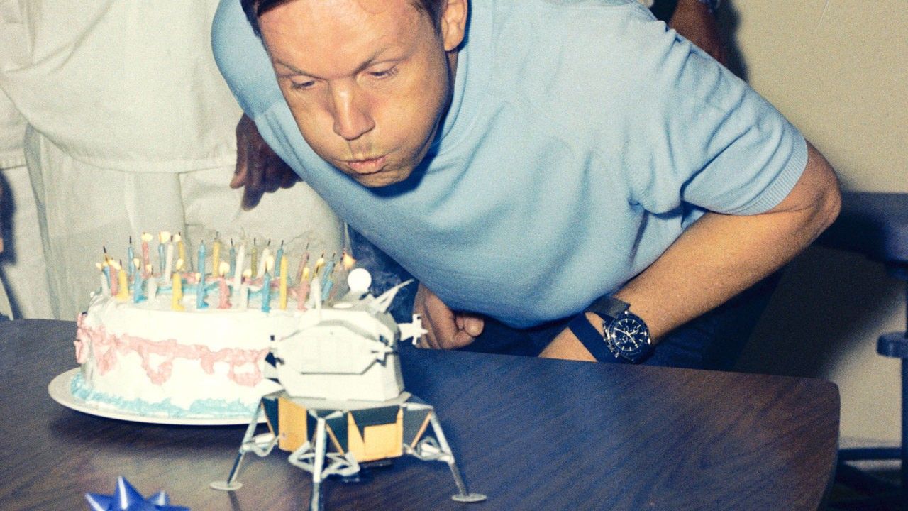 Neil Armstrong blowing out candles on a birthday cake.