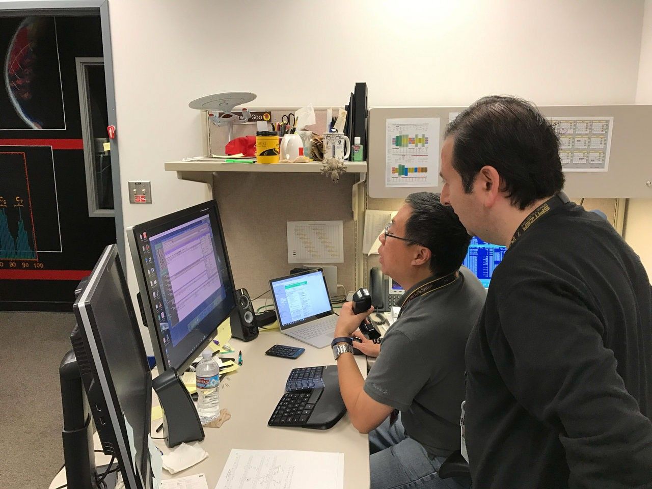 Two men at computer consoles.
