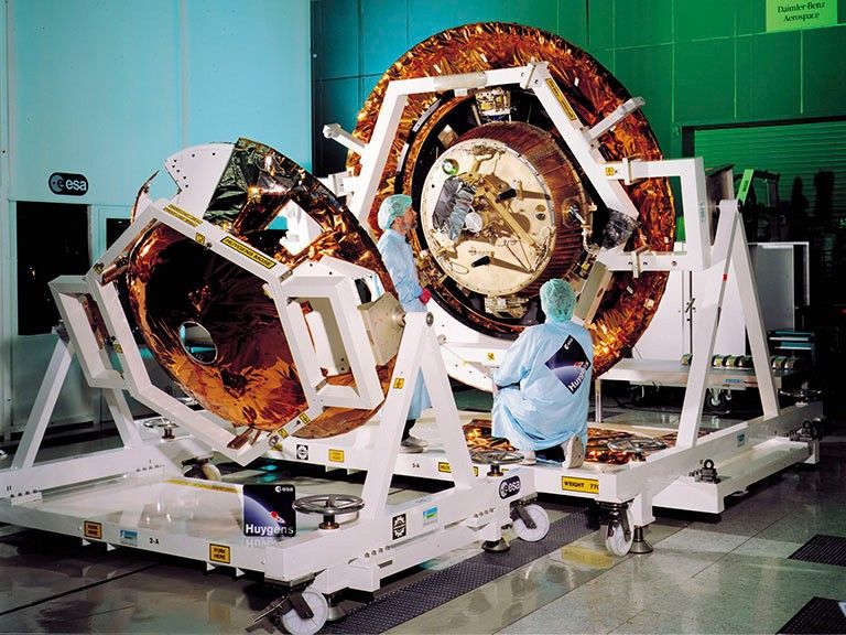 Color image of engineers working on spacecraft.