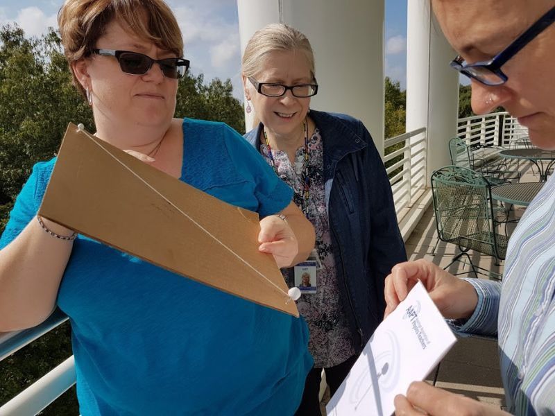 Three adult learners gathered around the model.