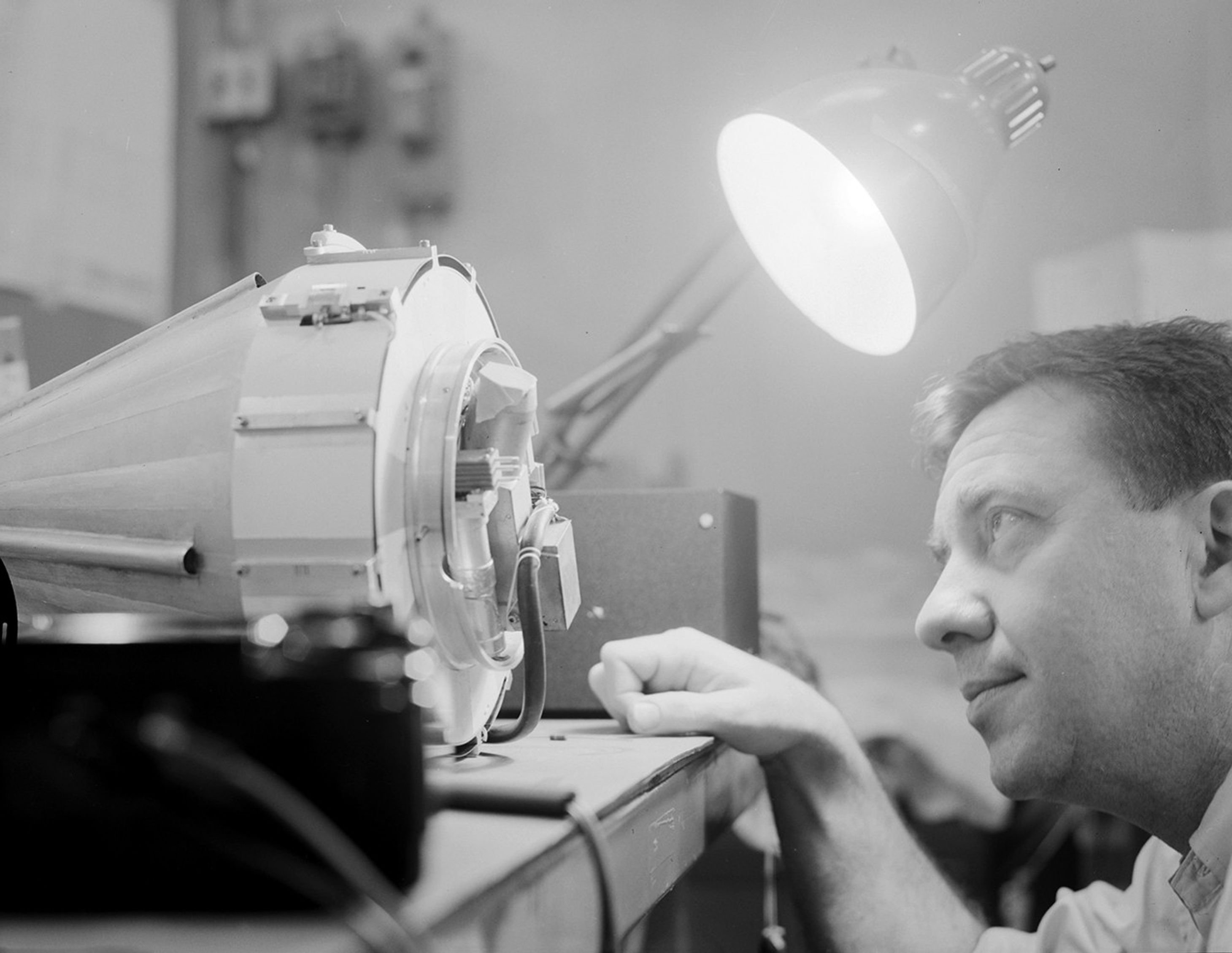 Man looking inside small spacecraft.