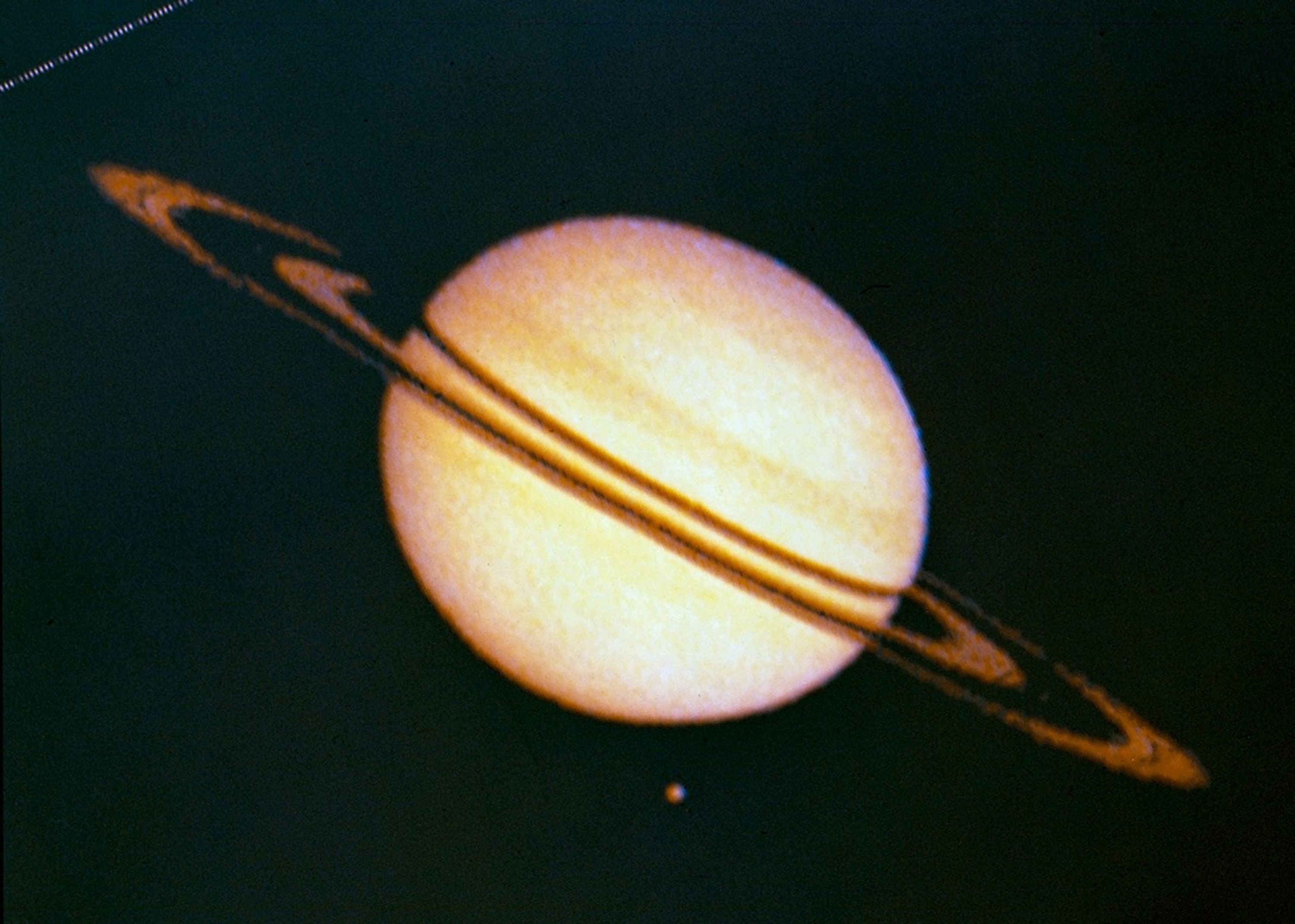 Fuzzy view of Saturn, it's rings and the giant moon Titan.