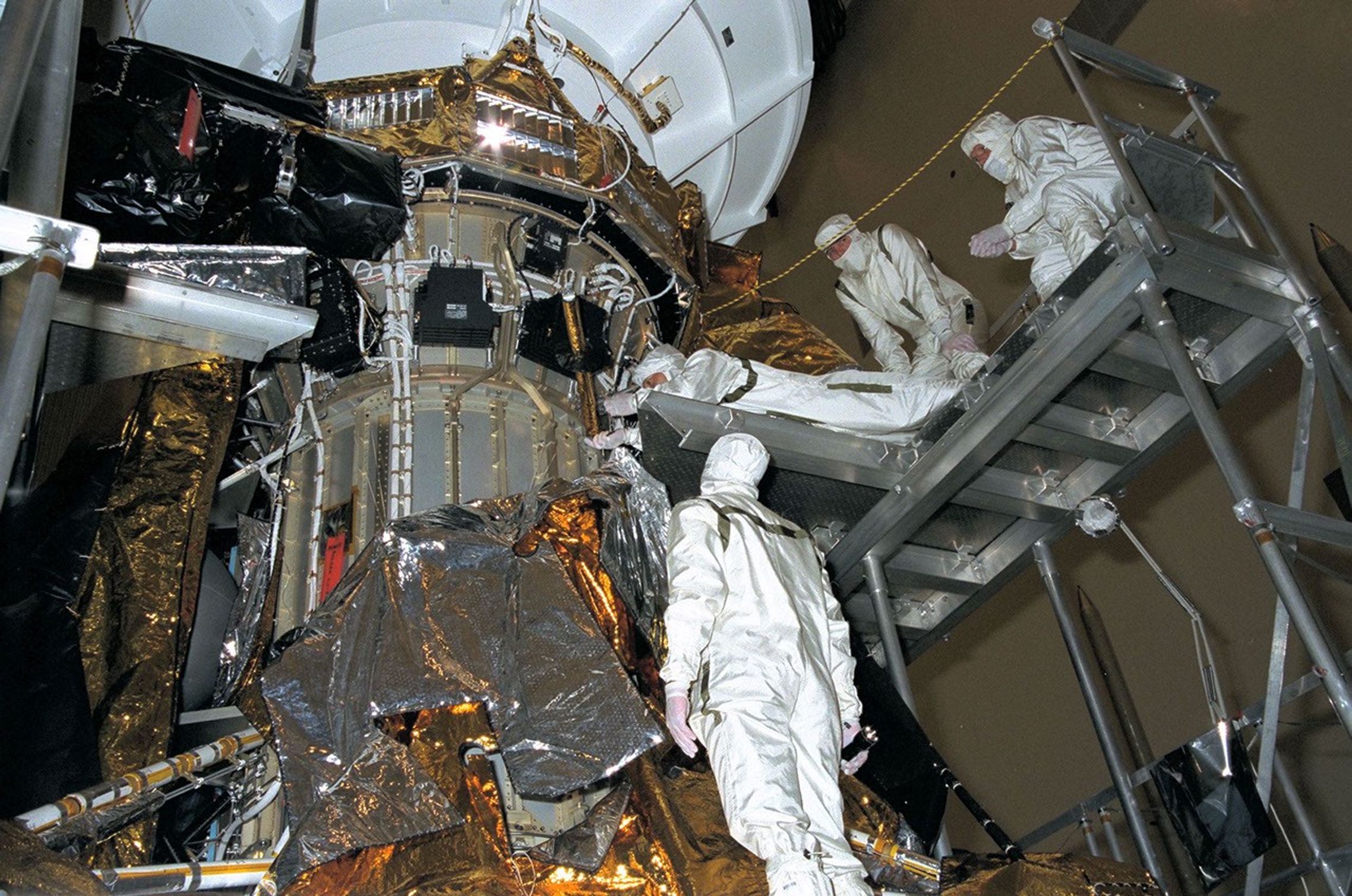 Four men working on a spacecraft.
