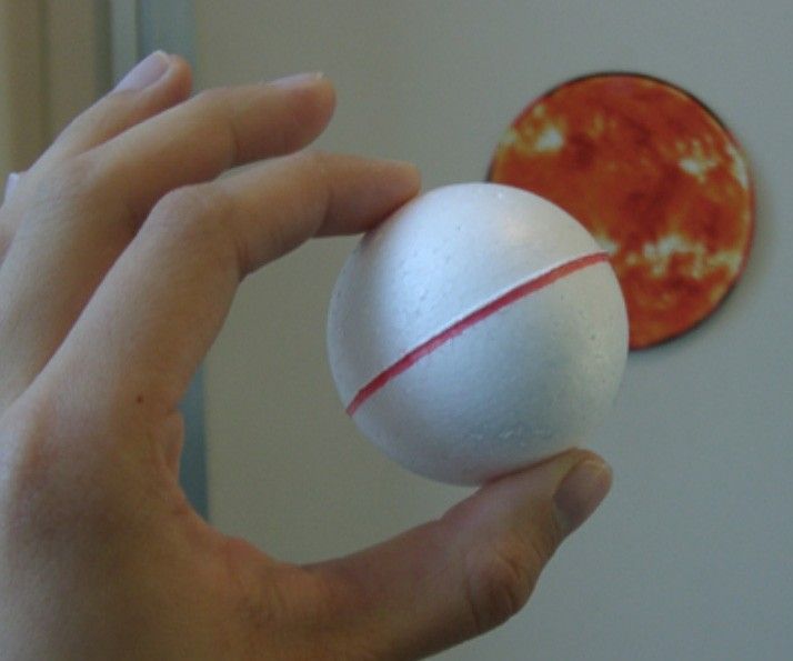 hand holding a small ball to represent the moon
