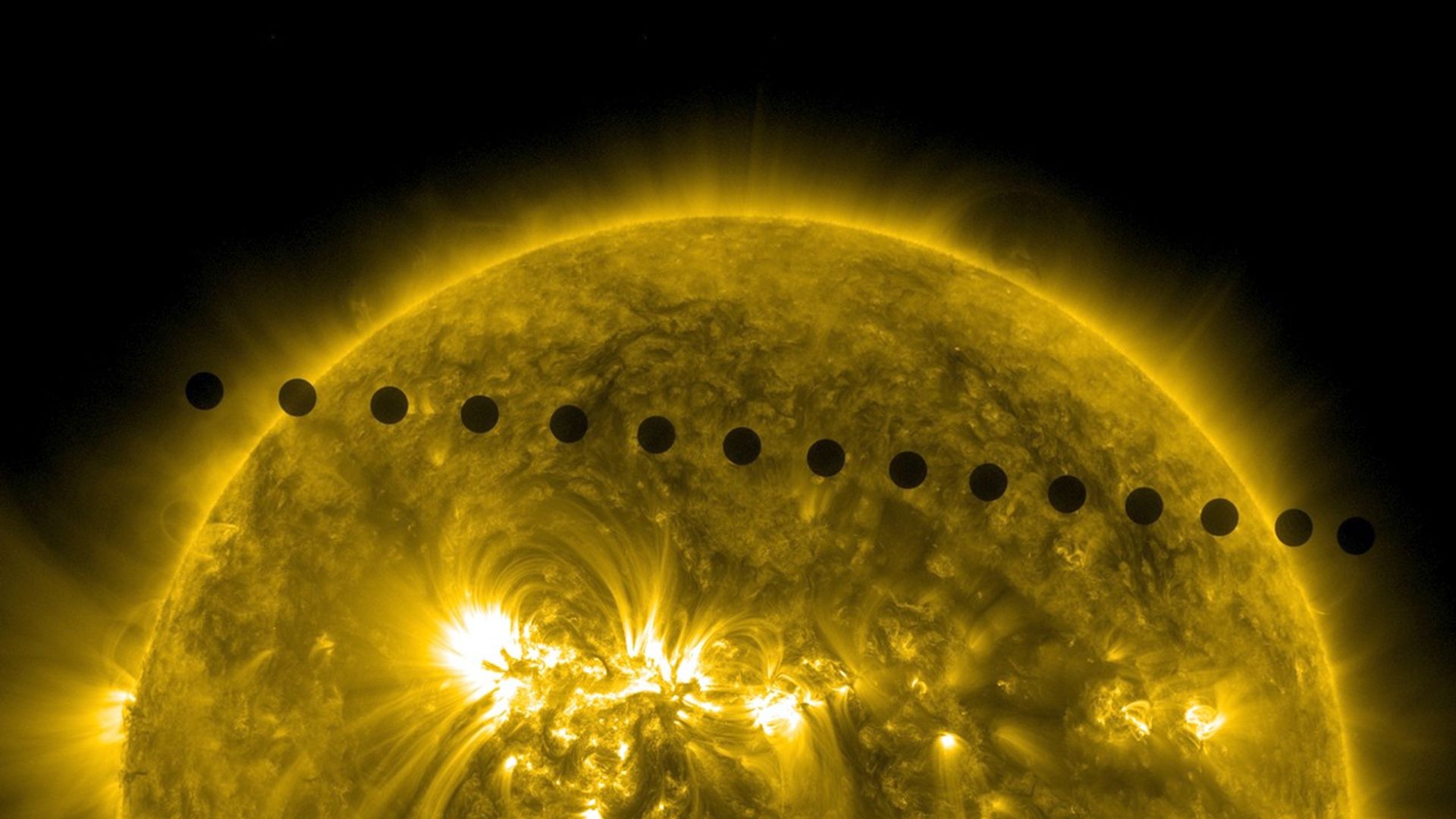 A sequence of black silhouettes of a planet transiting across the bright, glowing yellow surface of the Sun, showing different stages of the transit against the Sun’s outer atmosphere and swirling surface.