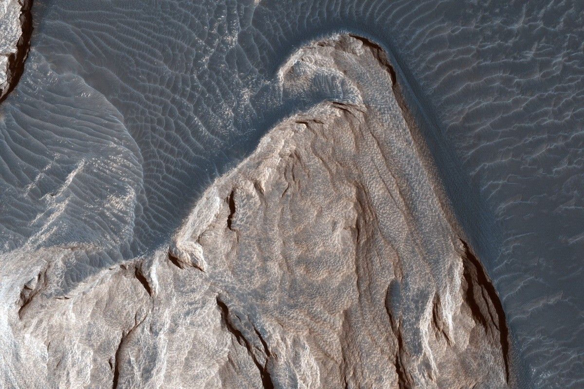rocky outcropping surrounded by dunes, seen from above