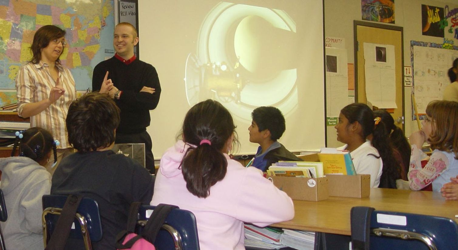 Two Cassini Science team members talking to students