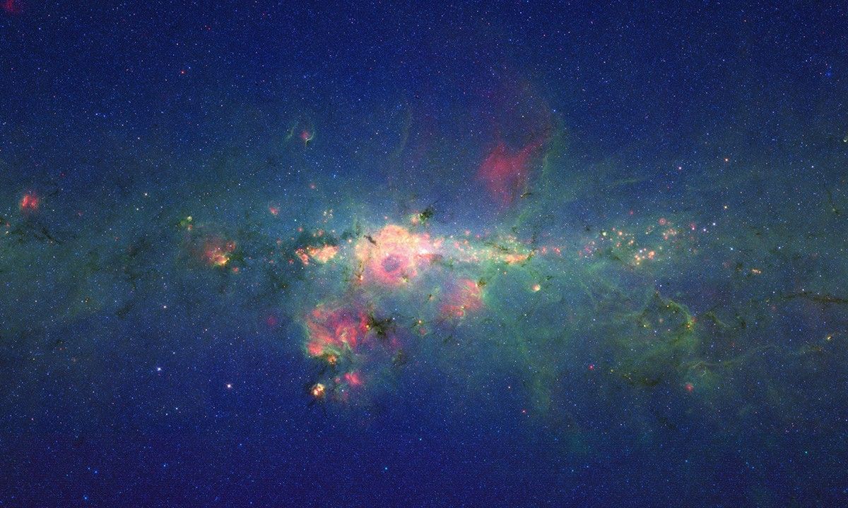 The region around the center of our Milky Way galaxy glows colorfully in this new version of an image taken by NASA's Spitzer Space Telescope.