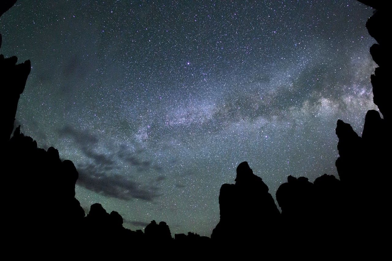 Vast field of stars above mountain pinnacles.