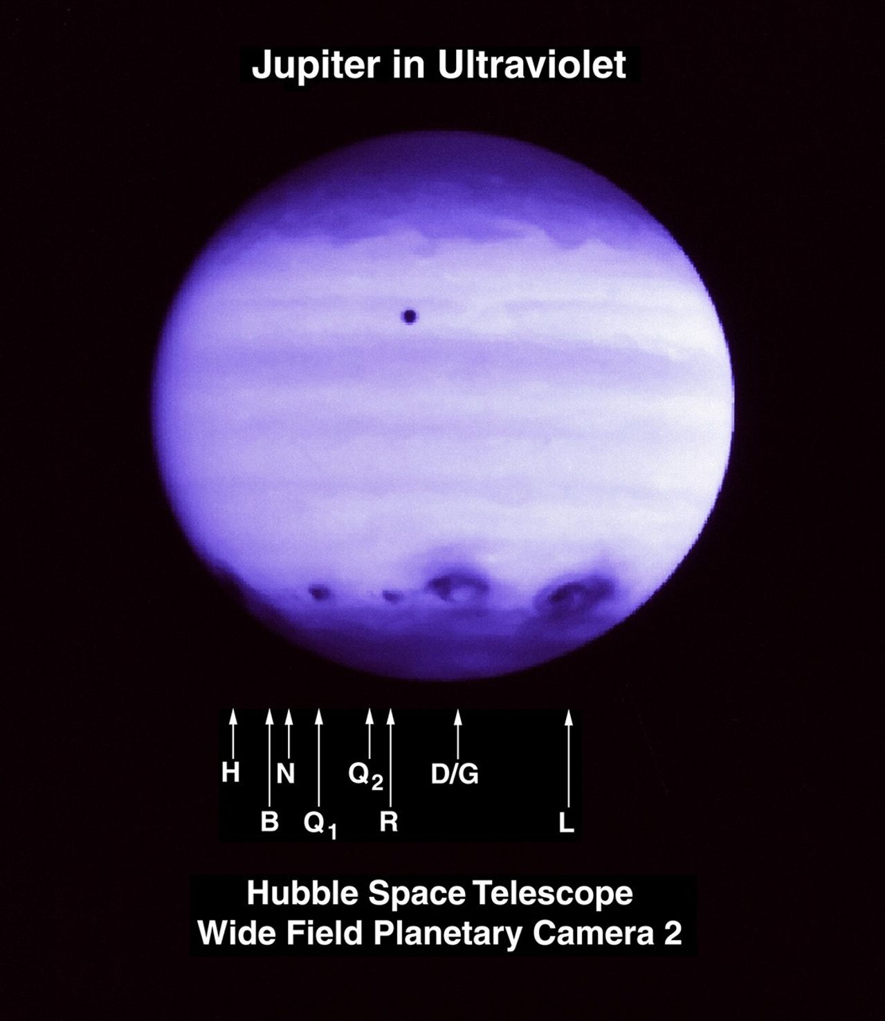 Purplish view of Jupiter with a band of dark impact images around the bottom quarter of the planet.