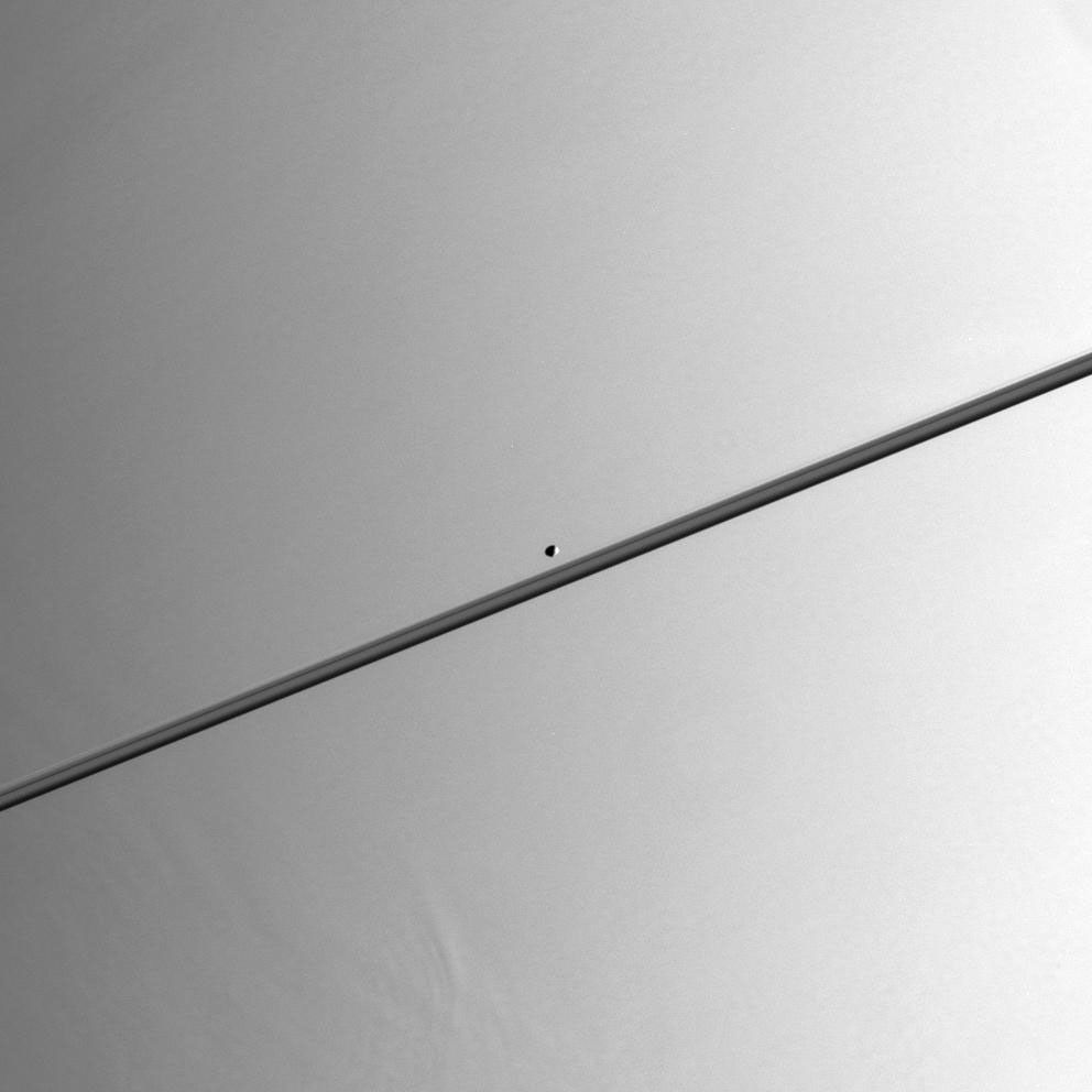 The moon Pandora with Saturn in the background. The F ring is thinly visible just above the main rings.