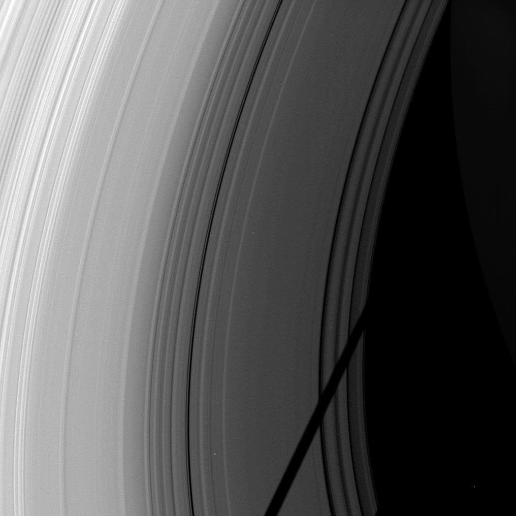 The shadow of the moon Tethys cuts across Saturn's rings