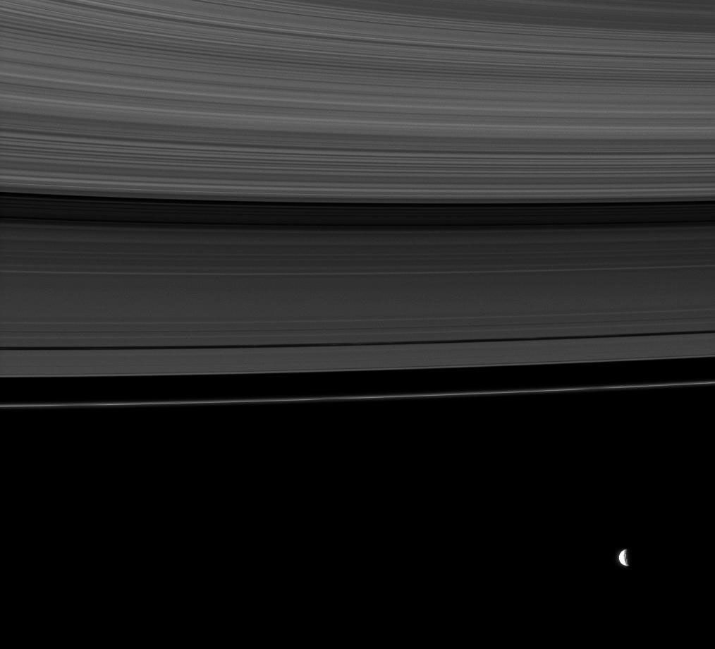 The rings share this view with Mimas, a moon whose gravity influences the rings.
