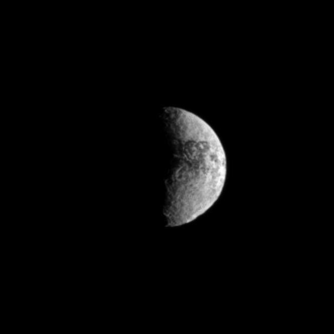 Craters give a rugged look to surface of Iapetus, especially in the large basin of Engelier visible along the southern limb of the moon in this view.