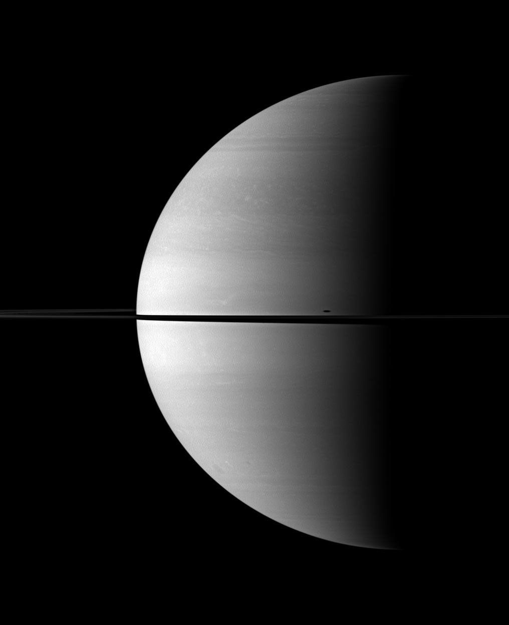 The shadow of Mimas is elongated across Saturn