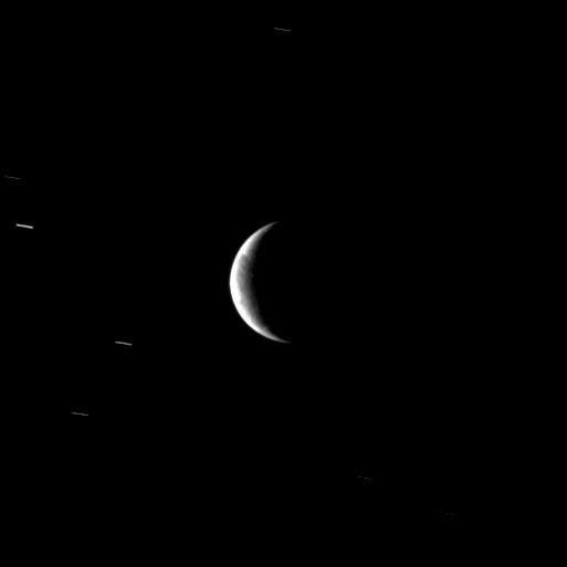 From a distant perspective, the Cassini spacecraft sees hints of the unusual surface of Saturn's moon Enceladus, a moon where new terrain is created around a geologically active south polar region.