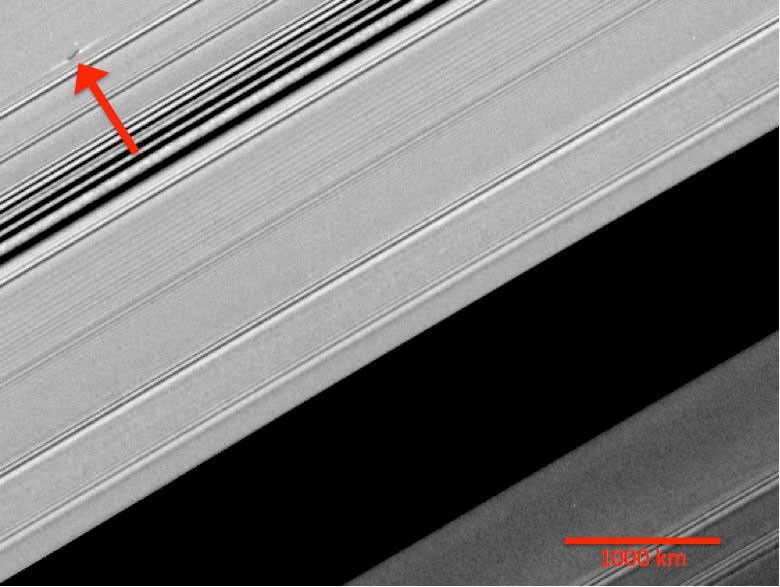 A propeller-shaped structure created by an unseen moon appears dark in this image obtained by NASA’s Cassini spacecraft of the unilluminated side of Saturn's rings.