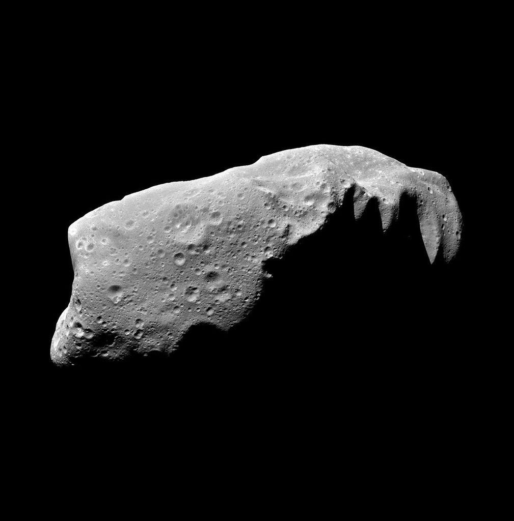 A long bumpy asteroid is shown with multiple craters.
