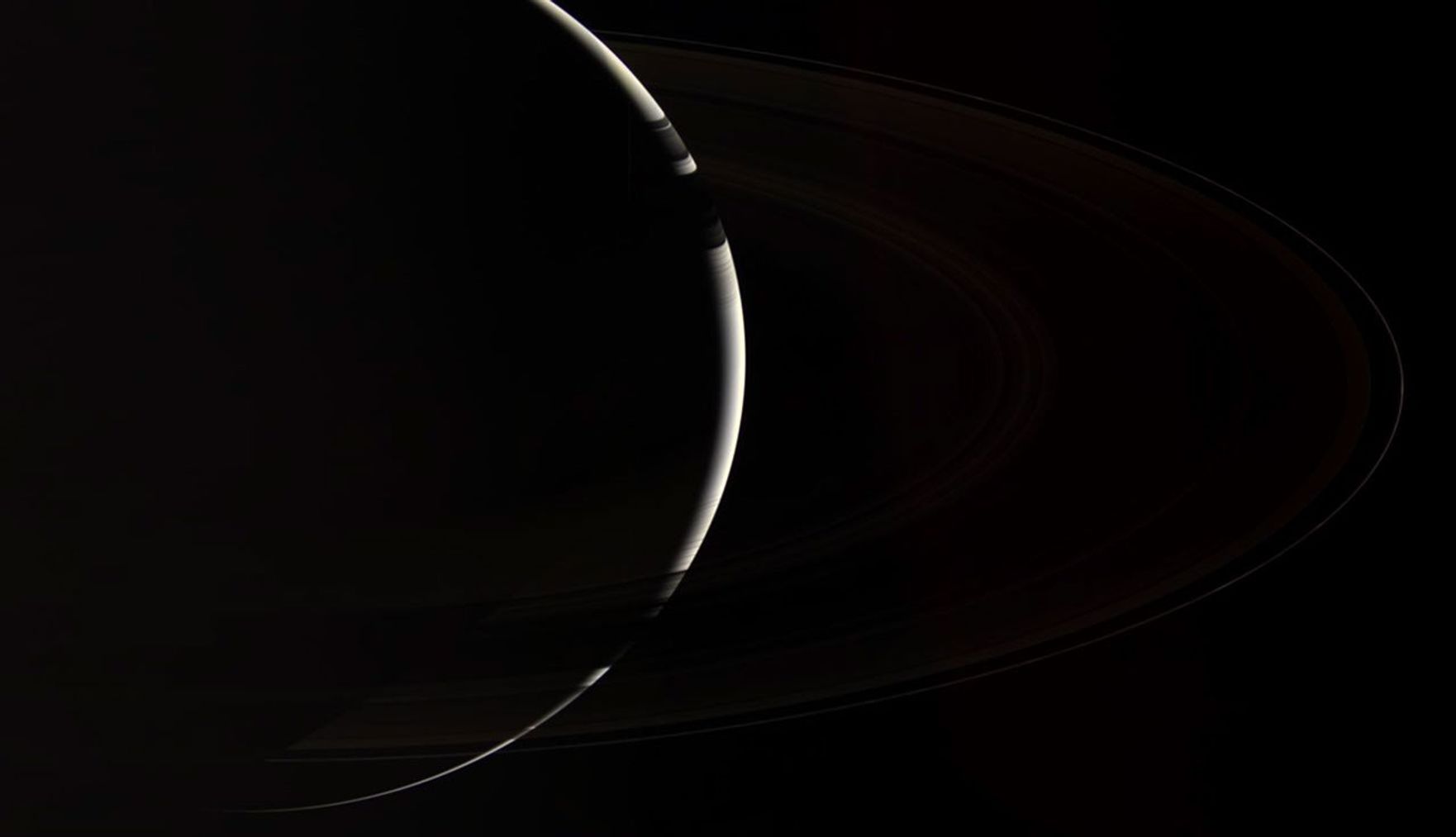 Only Cassini could provide this enchanting, natural color view of crescent Saturn, which gazes down onto the unlit side of the planet's spectacular rings.